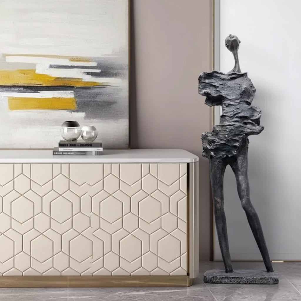 Modern interior with a sculpture, sideboard, and abstract painting.