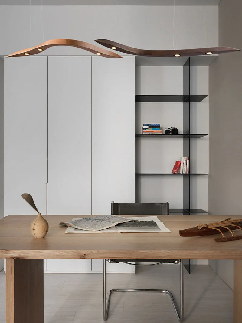 Modern office setup with a wooden desk, bookshelf, and chair against a gray wall.