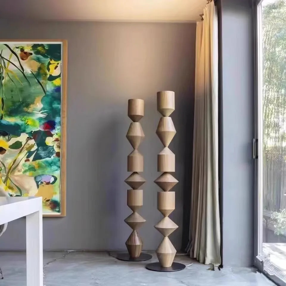 Decorative wooden sculptures in a modern interior setting with a painting on the wall.