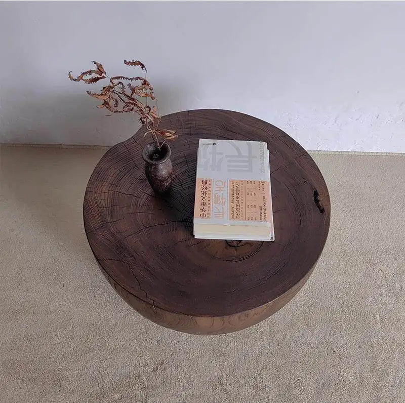 Wooden round table with a vase and book on a plain background
