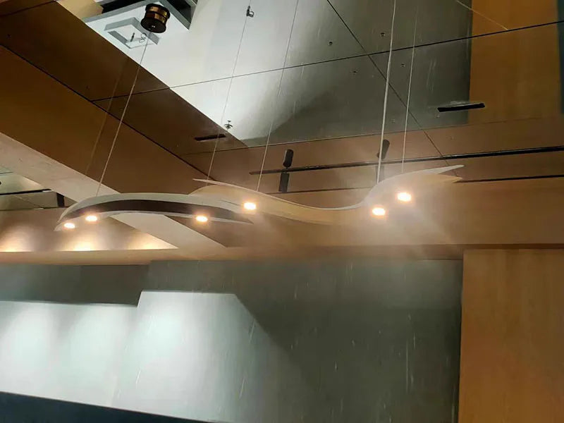 Modern ceiling light fixture in a room with reflective surfaces