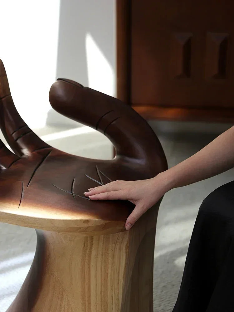 Wooden chair with a hand touching it, blurred background