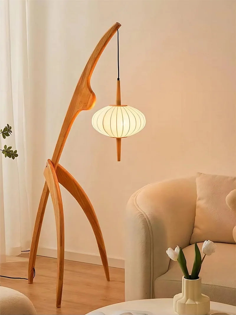 Wooden floor lamp with a hanging light fixture in a living room setting.