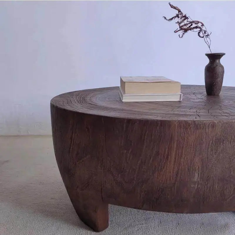 Wooden coffee table with a vase and books on a plain background