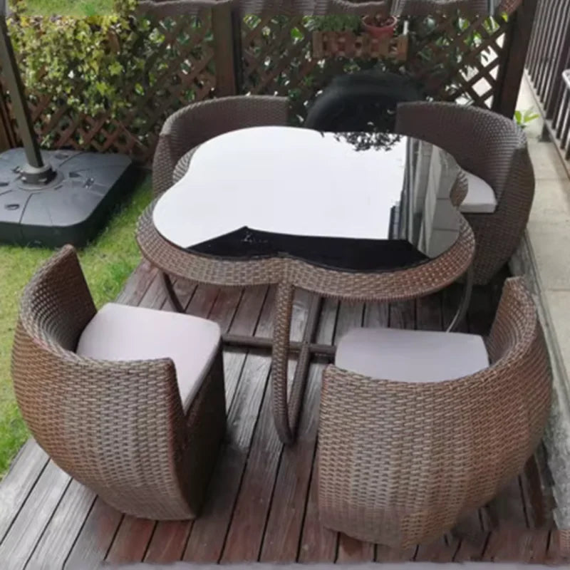 Outdoor patio set with wicker chairs and table on a wooden deck.