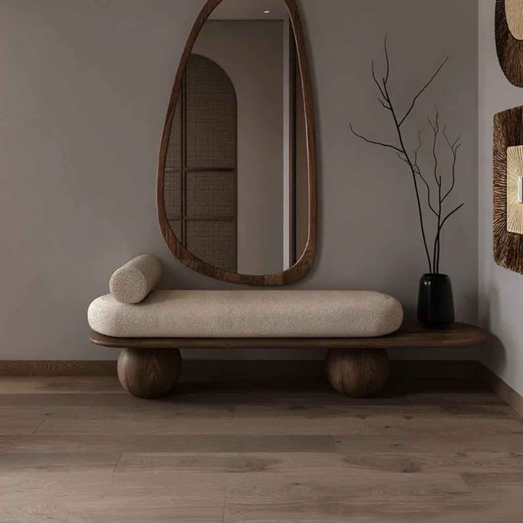 Modern interior with a bench, mirror, and decorative elements against a gray wall.
