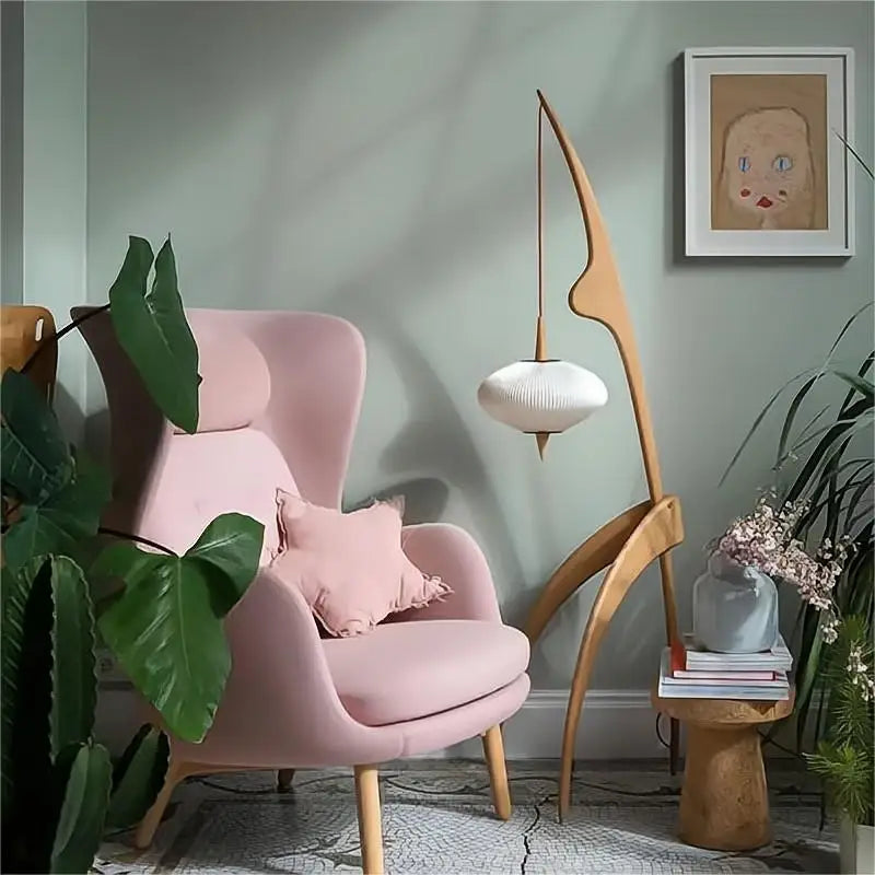 Pink armchair in a stylish room with a lamp and plants