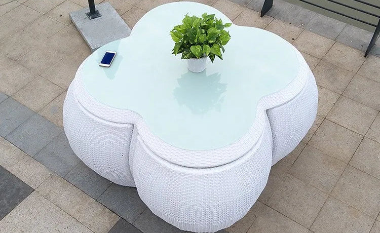 Modern outdoor furniture set with a white cloud-shaped table and chairs on a tiled patio.