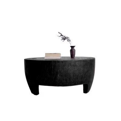 Black round coffee table with decorative items on a white background