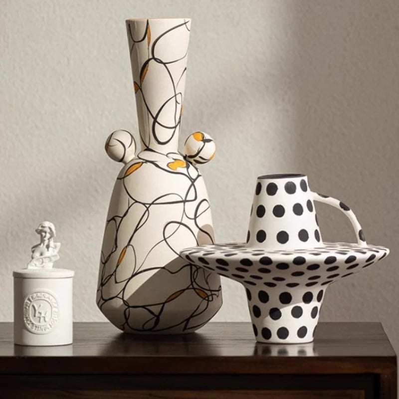 Three ceramic vases with unique designs on a wooden surface.