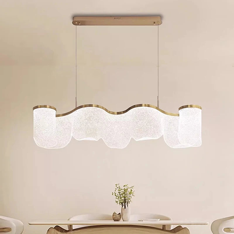 Modern pendant light fixture hanging above a dining table with a neutral background