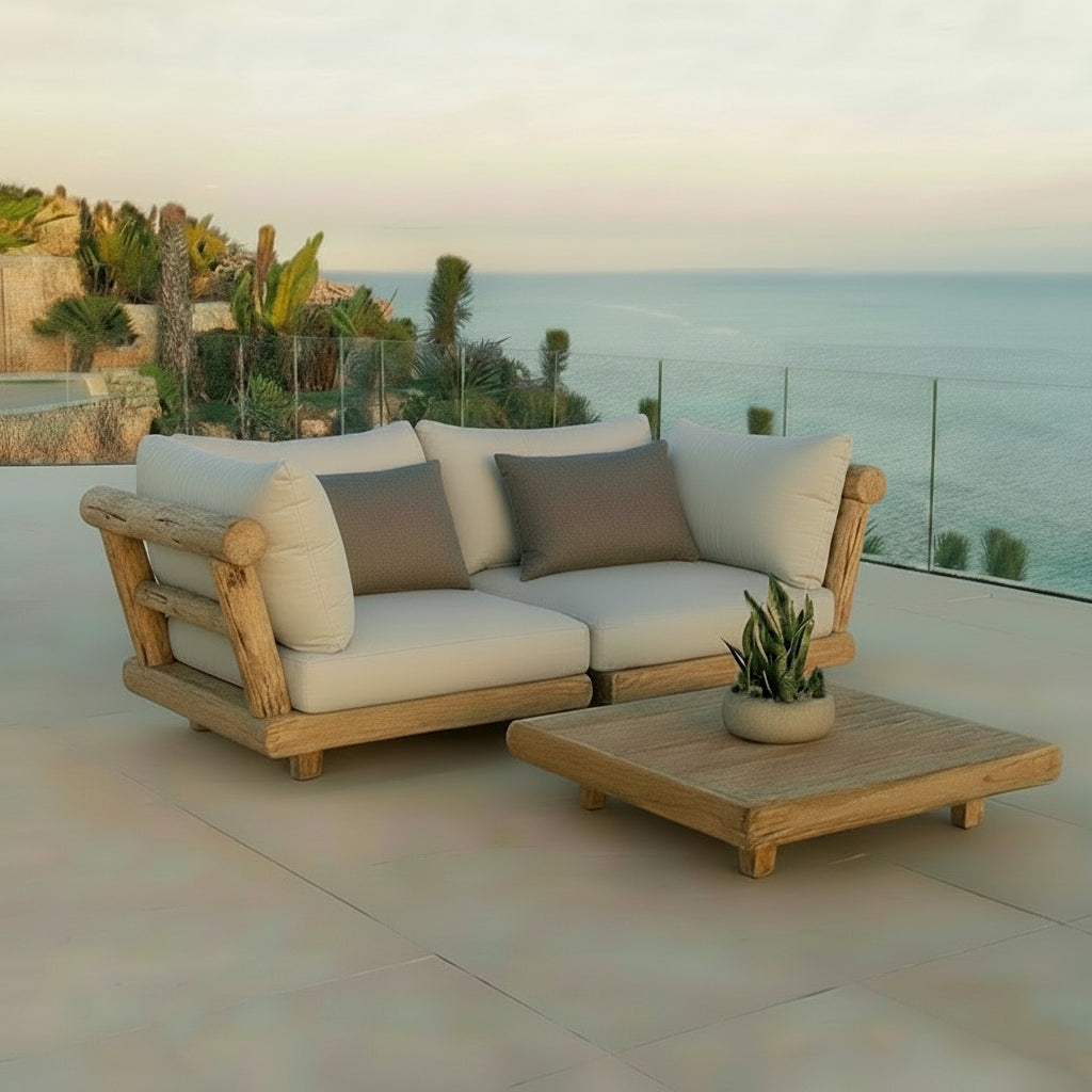 Outdoor patio set with wooden frame and beige cushions on a balcony with ocean view.