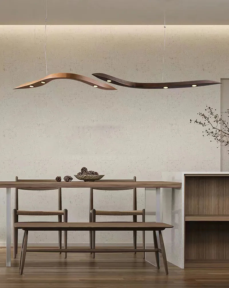 Modern dining area with wooden table and bench, featuring a stylish pendant light.