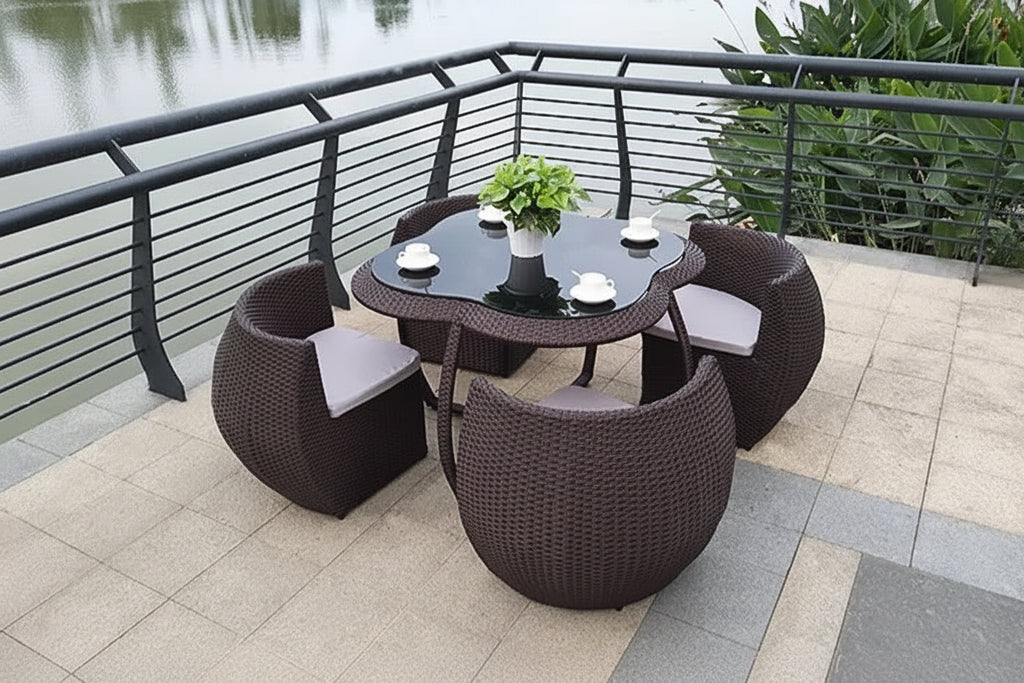 Outdoor patio set with table and chairs on a balcony overlooking water