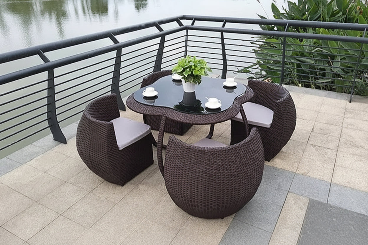 Outdoor patio set with table and chairs on a balcony overlooking water