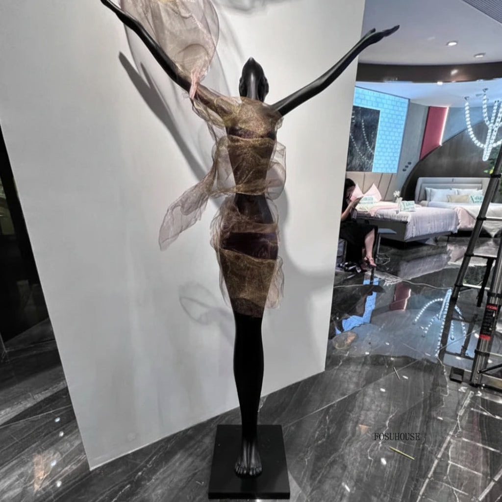 Artistic sculpture of a woman with outstretched arms in a modern indoor setting